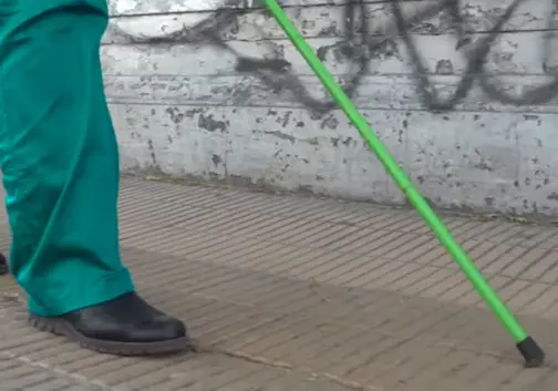 foto pessoa com defeciência visual seguindo sinalização